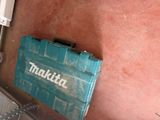 a makita tool box sitting on the floor next to a toilet