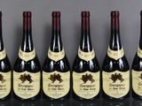 six bottles of wine are lined up on a table