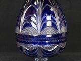 an egg shaped glass container with a blue and white design on it