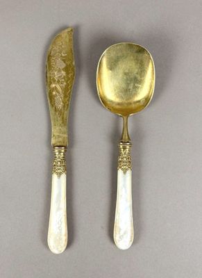 two spoons and a knife on a table with a gray background