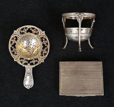 Deux objets en argent sont posés sur une surface noire, à côté d'un miroir.