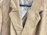 the jacket is hanging on a hanger in the closet