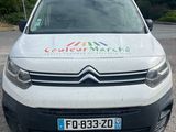a white van parked in a parking lot with trees in the background