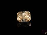 un diamant jaune sur une surface noire, avec un fond noir