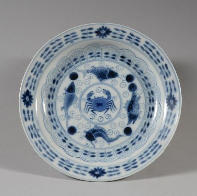 une assiette bleue et blanche sur laquelle est représenté un crabe