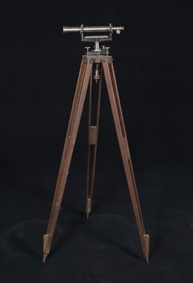 un télescope en bois monté sur un trépied, sur fond noir