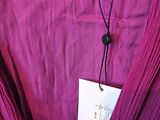 a close up of a purple dress with a tag on it