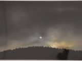 the sun is shining through the clouds over a forest