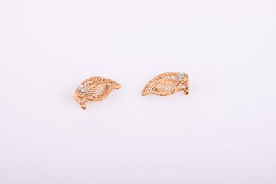 une paire de boucles d'oreilles en or sur fond blanc