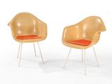 pair of mid century eames chairs with upholstered seat cushions