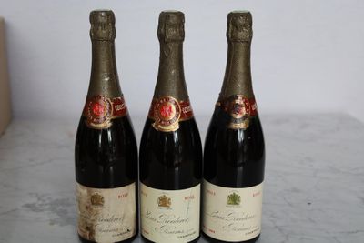 three bottles of wine sitting on a table next to each other