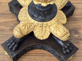 a gold and black candle holder on a wooden table