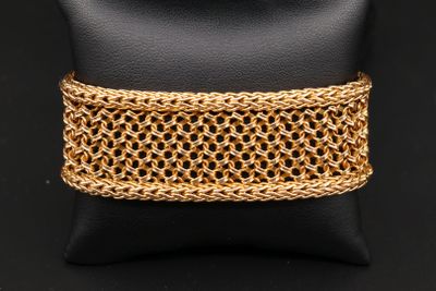 un gros plan d'un bracelet à maillons dorés posé sur un coussin noir