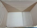 une boîte en carton percée d'un trou, posée sur une surface bleue