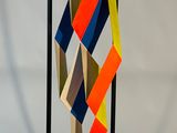 une sculpture en papier coloré posée sur un socle noir