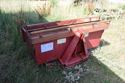 a red dumpster sitting in the middle of a field