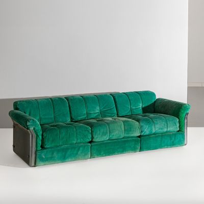 un canapé en velours vert dans une pièce blanche aux murs blancs