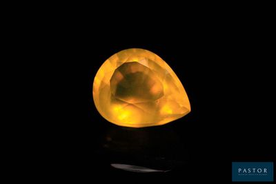 a close up of a yellow diamond on a black surface