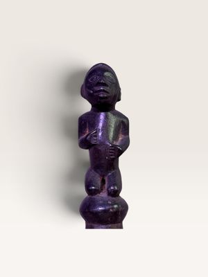une image représentant une figurine violette posée sur une surface blanche