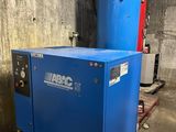 a blue compressor sitting on top of a pallet in a warehouse