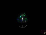 a close up of a ring with green and blue lights in the dark