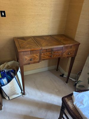 une petite table en bois sur laquelle est posé un sac, dans un coin de la pièce