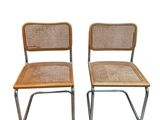 une paire de chaises vintage avec des dossiers en osier et des pieds chromés
