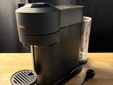 La cafetière est posée sur la table, à côté d'un verre.