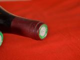 two bottles of wine sitting on a red cloth