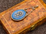 une petite boîte ornée d'un cadenas bleu et or