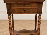 une vieille table en bois surmontée d'un tiroir, posée sur un parquet en bois massif