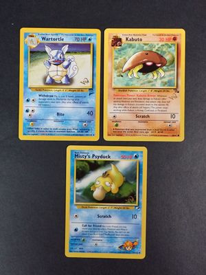three pokemon cards are sitting on a table with a black background