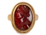 a close up of a gold ring with a red stone in the center