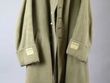 a green coat is hanging on a hanger on a wall