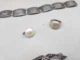 a bracelet, a ring, and a ring with a pearl on it