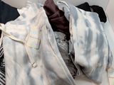 a pile of clothes sitting on a shelf in a room