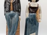 two figurines of a man and a woman standing next to each other
