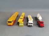 five different types of toy trucks lined up on a table