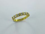 a yellow gold ring with five diamonds on a white background