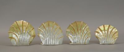 three glass vases with leaves on them sitting on a table