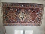 an oriental rug hanging on a wall in a room