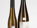 deux bouteilles de vin posées l'une à côté de l'autre sur une surface blanche