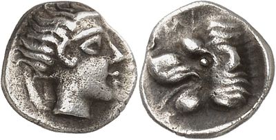 a silver coin with a head of a bull and a face of a woman