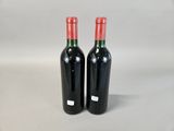 two bottles of red wine sitting next to each other on a table