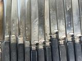 a lot of knives that are lined up on a shelf