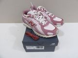pink new balance shoes with white laces on top of a box