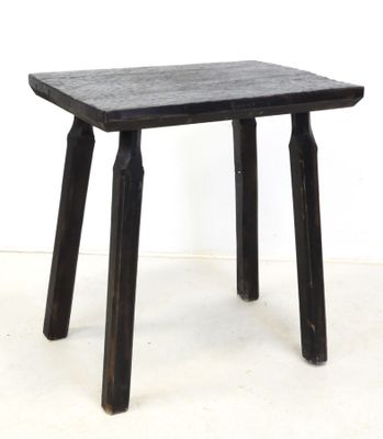 a small wooden table with two legs on a white floor