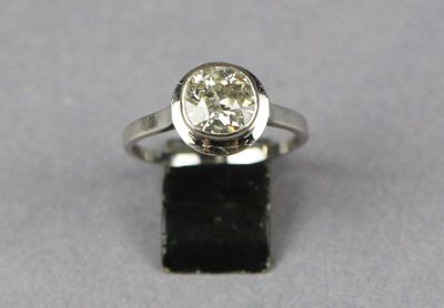 a close up of a ring with a diamond on a black surface