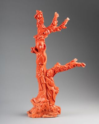 an orange figurine of a tree with a bird perched on it