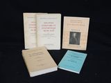 trois livres sont posés sur une surface noire, sur fond noir